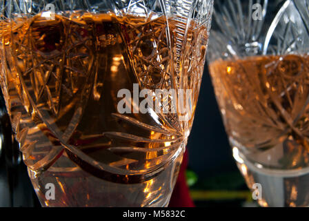 Verres en cristal à facettes vintage avec du vin blanc sur un fond sombre, l'accent sur la surface de la vitre avant Banque D'Images
