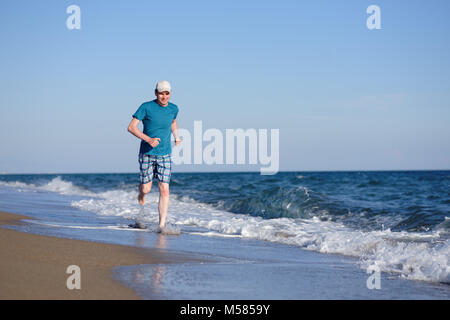 Barefoot man pendant le jogging sur une plage Banque D'Images