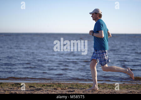 Barefoot man pendant le jogging sur une plage Banque D'Images