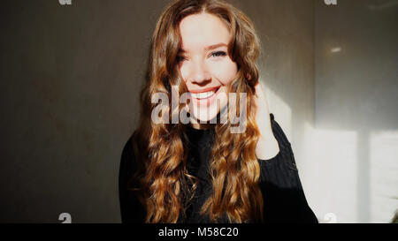 Jeune femme souriante, Looking at Camera avec les cheveux bouclés Banque D'Images