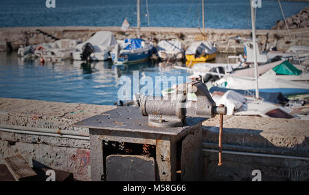 Etau à main sur le banc de métal sur le port en arrière-plan flou. Banque D'Images