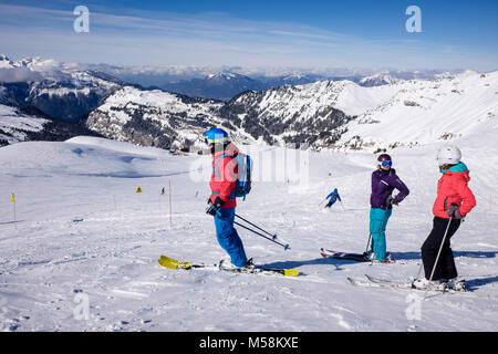 Ski skieurs sur red route de ski dans le domaine skiable du Grand Massif dans les Alpes en hiver la neige au-dessus de Flaine, Haute Savoie, Rhône-Alpes, France, Europe Banque D'Images