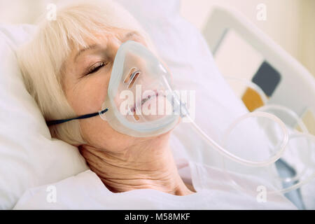 Close up of retired dame avec une assistance respiratoire à l'hôpital Banque D'Images