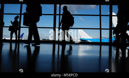 Les voyageurs avec des valises et des bagages dans l'aéroport pour les départs de marche en face de fenêtre, silhouette Banque D'Images