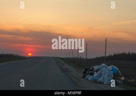 Décharge le long de la route au coucher du soleil - ecology concept Banque D'Images