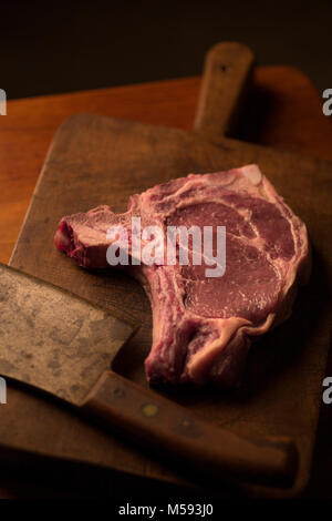 T-bone steak de boeuf rôti avec un vintage cleaver sur une planche à découper Banque D'Images