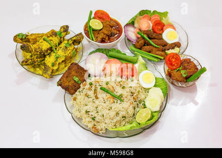 Bengali populaires indiens les plats avec du riz frit, les bâtonnets de poisson, mutton masala curry et tangra curry de poisson garni de salade. Banque D'Images