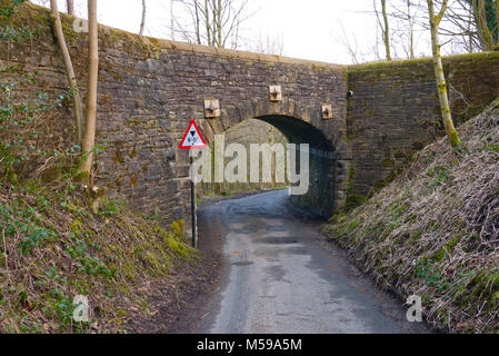 Signe de la limitation de hauteur par pont de pierre étroit, Bellevue, Greater Manchester, UK. Banque D'Images