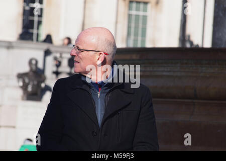 Un vieux, chauve, à travers en quelque chose qui a attiré son oeil dans le soleil d'hiver, Trafalgar Square Londres Banque D'Images