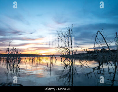 Coucher de soleil sur le lac Grand Texas avec arbres morts sortant de l'eau Banque D'Images