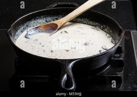 Faire une sauce aux champignons ou la sauce dans une poêle en fonte ou à frire Banque D'Images