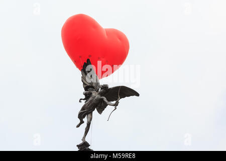 Piccadilly Circus, Londres, 21 février 2018. Un coeur chubby apparaît sur Piccadilly Circus et la statue d'Eros, un symbole de l'amour, dans le centre de Londres. Commençant le jour de la Saint-Valentin et tout au long de la Semaine de la mode de Londres, giant chubby ballons coeur par Anya Hindmarch sont suspendus au-dessus de Londres comme une déclaration d'amour à la ville. Les ballons disparaissent chaque soir et apparaissent à nouveau dans un autre endroit le jour suivant. Credit : Imageplotter News et Sports/Alamy Live News Banque D'Images