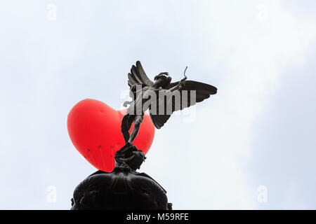 Piccadilly Circus, Londres, 21 février 2018. Un coeur chubby apparaît sur Piccadilly Circus et la statue d'Eros, un symbole de l'amour, dans le centre de Londres. Commençant le jour de la Saint-Valentin et tout au long de la Semaine de la mode de Londres, giant chubby ballons coeur par Anya Hindmarch sont suspendus au-dessus de Londres comme une déclaration d'amour à la ville. Les ballons disparaissent chaque soir et apparaissent à nouveau dans un autre endroit le jour suivant. Credit : Imageplotter News et Sports/Alamy Live News Banque D'Images