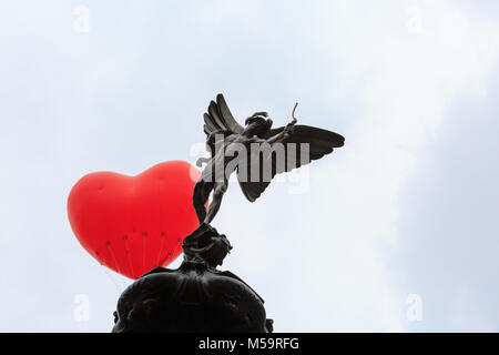 Piccadilly Circus, Londres, 21 février 2018. Un coeur chubby apparaît sur Piccadilly Circus et la statue d'Eros, un symbole de l'amour, dans le centre de Londres. Commençant le jour de la Saint-Valentin et tout au long de la Semaine de la mode de Londres, giant chubby ballons coeur par Anya Hindmarch sont suspendus au-dessus de Londres comme une déclaration d'amour à la ville. Les ballons disparaissent chaque soir et apparaissent à nouveau dans un autre endroit le jour suivant. Credit : Imageplotter News et Sports/Alamy Live News Banque D'Images