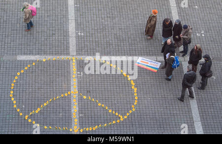 Stuttgart, Allemagne. Feb 21, 2018. Un signe de paix faite de gerbera se trouvant en face de l'hôtel de ville au cours d'une campagne artistique sur le 60e anniversaire de la 'paix' sign in Stuttgart, Allemagne, 21 février 2018. Land du Bade-Wurtemberg Association de la paix - La société allemande United opposants du Service Militaire prévues autour de 200 fleurs dans la forme d'un signe de la paix et ensuite distribué les fleurs aux passants. Crédit : Sébastien Gollnow/dpa/Alamy Live News Banque D'Images