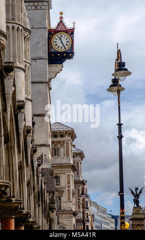 Royal Courts of Justice, l'horloge au Strand, London. Rangée de bâtiments sur le côté gauche, un lampadaire sur la droite. Fer à repasser statue de dragon sur le bas à droite. Portrait. Banque D'Images