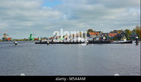 Bateau remorqueur tirant une péniche sur la rivière Zaan Zaanse Schans, un village près de Zaandijk dans la municipalité de Zaanstad, Pays-Bas Banque D'Images