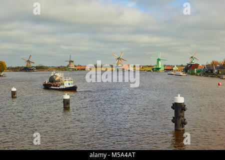 Bateau remorqueur tirant une péniche sur la rivière Zaan Zaanse Schans, un village près de Zaandijk dans la municipalité de Zaanstad, Hollande du Nord, Pays-Bas. Banque D'Images