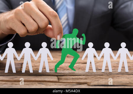 Portrait of businessman holding green paperman tournant au milieu de la table de l'équipe Banque D'Images