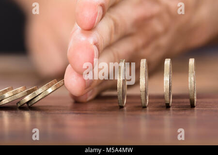 Portrait of businessman's hand protection coins de tomber tout en jouant sur la table domino Banque D'Images