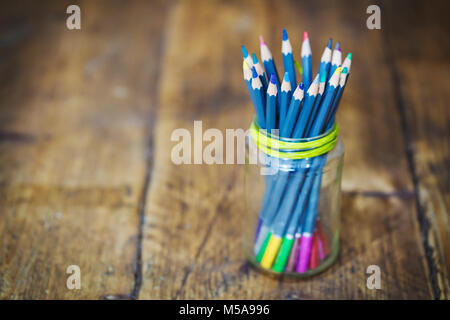 Close up of a glsa pot avec crayons de couleur bleue sur la table en bois. Banque D'Images