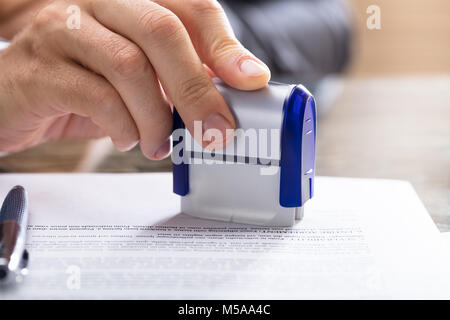 Close-up d'une main humaine Document estampage sur 24 Banque D'Images