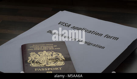 Un formulaire de demande de visa avec un passeport britannique au-dessus d'elle (la demande de visa concept) Banque D'Images