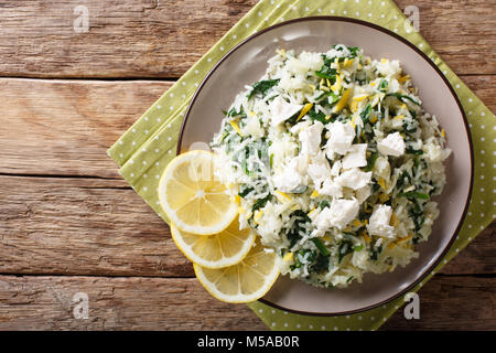 Spanakorizo riz avec les épinards, le zeste de citron et la féta close-up sur une assiette. Haut horizontale Vue de dessus Banque D'Images