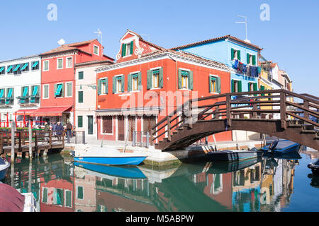 Pont de bois sur la Fondamenta di Cao Moleca, île de Burano, Venise, Vénétie, Italie avec des réflexions du bâtiments colorés dans le canal Banque D'Images