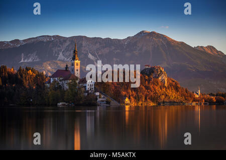 Bled, Slovénie - l'automne magnifique lever du soleil sur le lac de Bled avec la célèbre église de pèlerinage de l'assomption de Marie avec le Château de Bled et les Alpes Juliennes un Banque D'Images