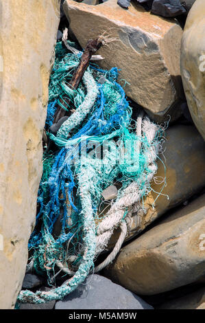 Cordes et filets de pêcheurs échoués sur la rive déposée entre les roches et les rochers sur la côte du Dorset. Banque D'Images