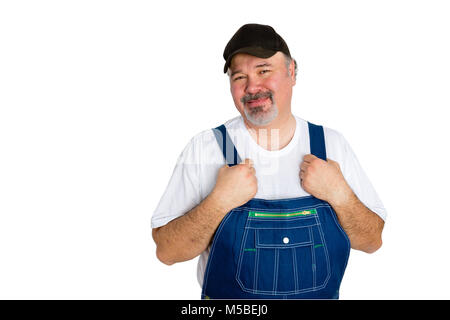 Portrait of smiling man wearing salopette et cap standing against white background Banque D'Images