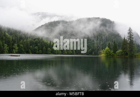 Un brumeux et des forêts pluviales tempérées montagneuses reflétée dans un lac à Clements Lake Zone de loisirs dans le Nord de la Colombie-Britannique, Canada. Banque D'Images