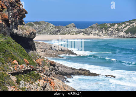 Une vue sur la côte et la plage de Robberg près de Plettenberg Bay en Afrique du Sud avec des vagues dans l'Océan Indien et un ciel bleu Banque D'Images