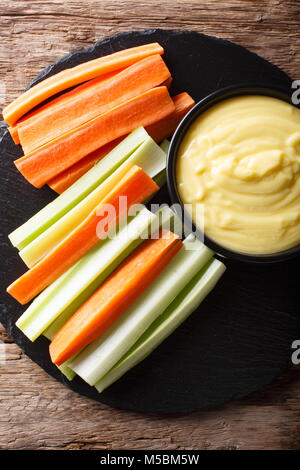 Des bâtonnets de carotte et de céleri avec trempette crémeuse au fromage sur un gros plan sur la table. Haut Vertical Vue de dessus Banque D'Images