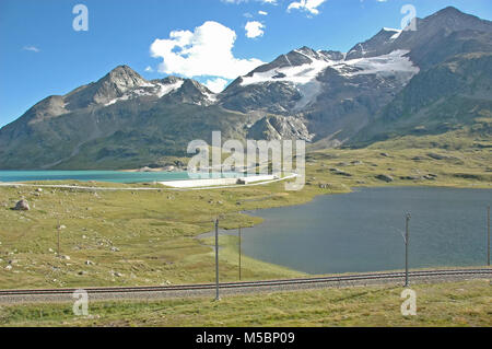 Vue depuis le col de la Bernina, dans le sud de la Suisse au-dessus de St Moritz, avec les lignes de chemin de fer de la Bernina Express qui traverse le col. Lacs et Bi Banque D'Images