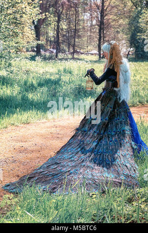 19 avril 2014, les Pays-Bas, Haarzuilens : belle femme vêtue d'une robe de paon pose dans le parc au cours de l'Elf Fantasy Fair (Elfia) est un Banque D'Images