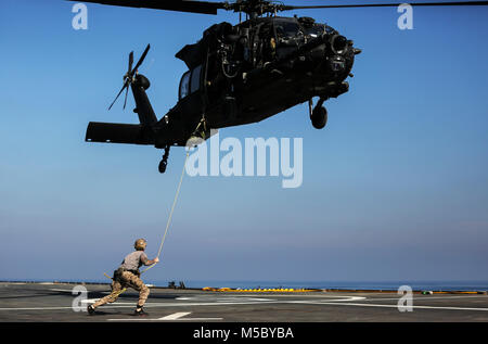 U.S. 5ÈME ZONE DES OPÉRATIONS DE LA FLOTTE (fév. 6, 2018) U.S. Naval Special Warfare forces canadiennes se préparent à fast corde hors de l'armée américaine Special Operations Aviation Regiment UH-60 Black Hawk sur le pont du navire d'assaut amphibie Français LHD Tonnerre (L9014) au cours d'un entraînement bilatéral l'évolution. Le Tonnerre, est lancé avec des Marines et marins de la Force amphibie de la Marine, Groupe de travail 51/5ème Marine Expeditionary Brigade et US Special Operations Forces mènent des opérations de sécurité maritime au sein de la 5e flotte américaine zone des opérations afin d'assurer la stabilité régionale, la liberté de navigation et la libre fl Banque D'Images