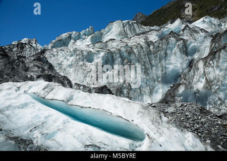 Cascade de Fox Glacier sur l'île du sud de Nouvelle-Zélande. Une petite crevasse est ouvert vers l'appareil photo et de grands séracs de glace pendent au-dessus. Banque D'Images