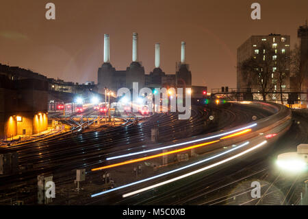 Londres, Angleterre, Royaume-Uni - 12 janvier 2013 : Le sud du passage des trains Battersea Power Station sur l'approche de la gare de Victoria à Londres la nuit. Banque D'Images