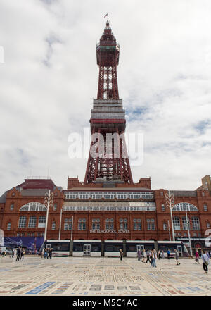 Blackpool, England, UK - 1 août 2015 : un tramway moderne passe le long de la promenade de Blackpool, où les touristes à pied sous la célèbre Tour de Blackpool. Banque D'Images