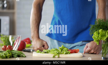 Jeune homme pour préparer une salade verte fraîche dans la cuisine, la cuisson, les séquences mari Banque D'Images