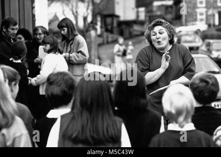 Professeur de musique chorale pour enfants en tenant dans la pratique à l'extérieur à l'eisteddfod en petite salle des fêtes à St Dogmaels Llandudoch Dyfed West Wales UK Banque D'Images