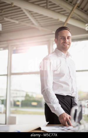Portrait of handsome Young Man at desk in office Banque D'Images