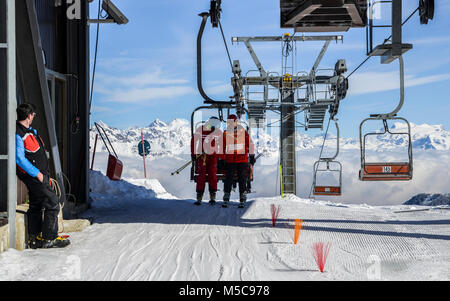 Pila, Aoste, Italie - Dec 19, 2018 : Vieil Homme et adolescent descendre d'un télésiège au ski avec majestic Alpes italiennes en arrière-plan Banque D'Images