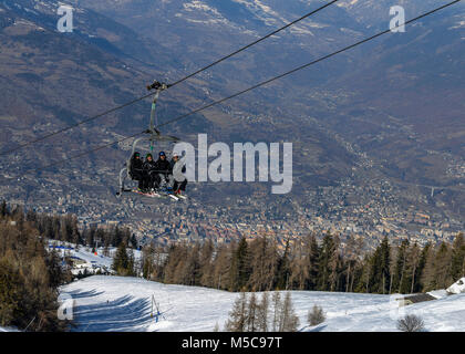 Les hommes âgés moyens quatre skieurs prendre un télésiège jusqu'à la montagne de ski de Pila en Vallée d'aoste, Italie. Ville d'aoste, Italie Banque D'Images