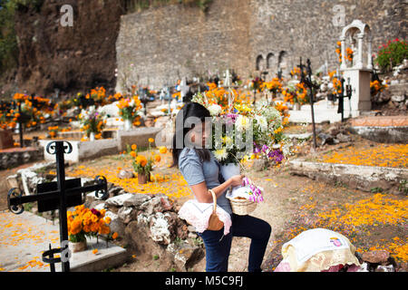 Une jeune fille décore graves sur l'île de Janitzio au cours de Dia de los Muertos (Jour des Morts) Célébrations dans le lac de Patzcuaro, près de Patzcuaro, Michoacan, Mexique le samedi, Novembre 1, 2014. Dia de los Muertos (Jour des morts) est une maison de vacances traditionnelle centrée autour de se rappeler et honorer les membres de la famille du défunt. Loin d'une sombre affaire, Dia de los Muetros est une célébration de la vie. Patzcuaro, une ville pittoresque dans l'état de Michoacan, Mexique (sept heures à l'ouest de la ville de Mexico), attire les touristes du monde entier dans les jours précédant la Dia de los Muertos (1er et 2ème). Banque D'Images