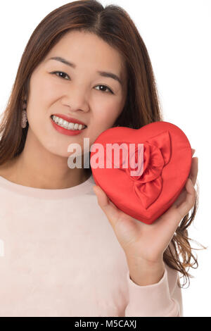 Asian woman jouissant d'un don spécial d'une boîte de chocolats dans un cœur rouge isolé sur fond blanc Banque D'Images