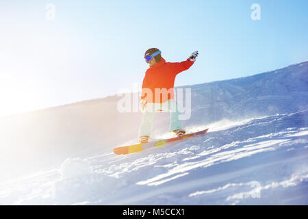 Dame snowboarder à ski dans la lumière du soleil Banque D'Images