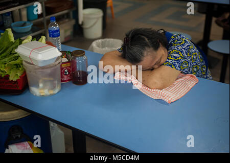 26.01.2018, Singapour, République de Singapour, en Asie - une femme âgée pan à une table à l'intérieur d'une cour à l'alimentaire complexe dans le quartier chinois de Chinatown. Banque D'Images